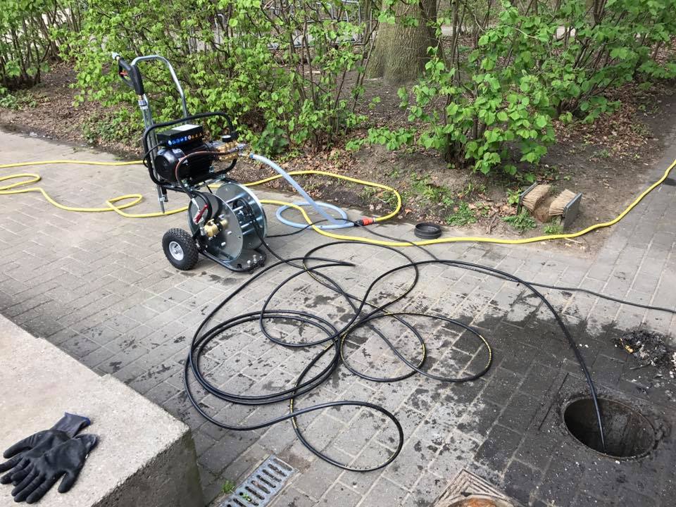 Ontstoppingsmachine met slanghaspel buiten een woning